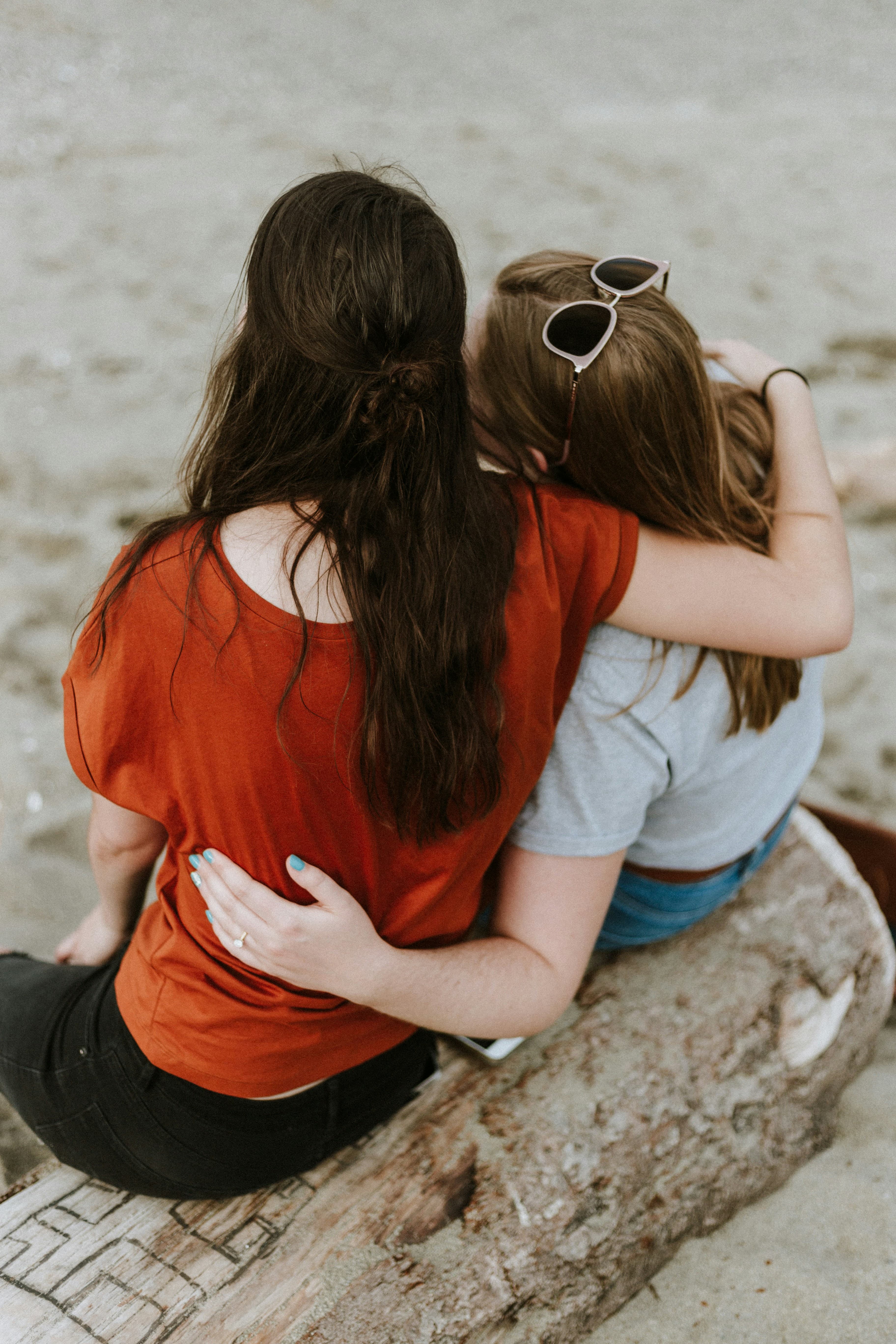 2 females hug each other in support of each other.